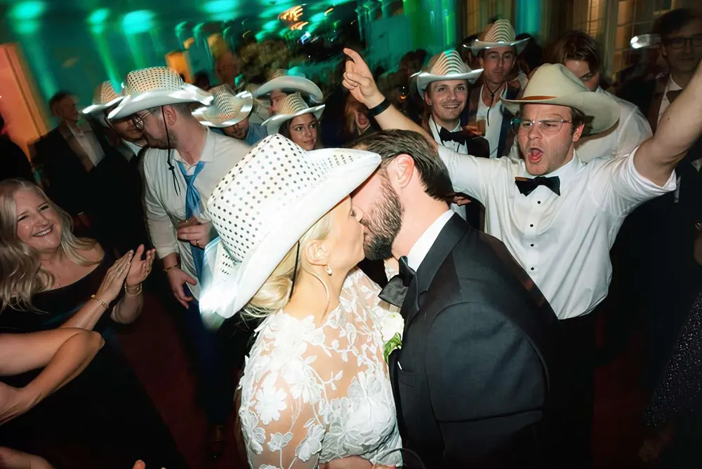 Wedding guests celebrating outdoors under string lights